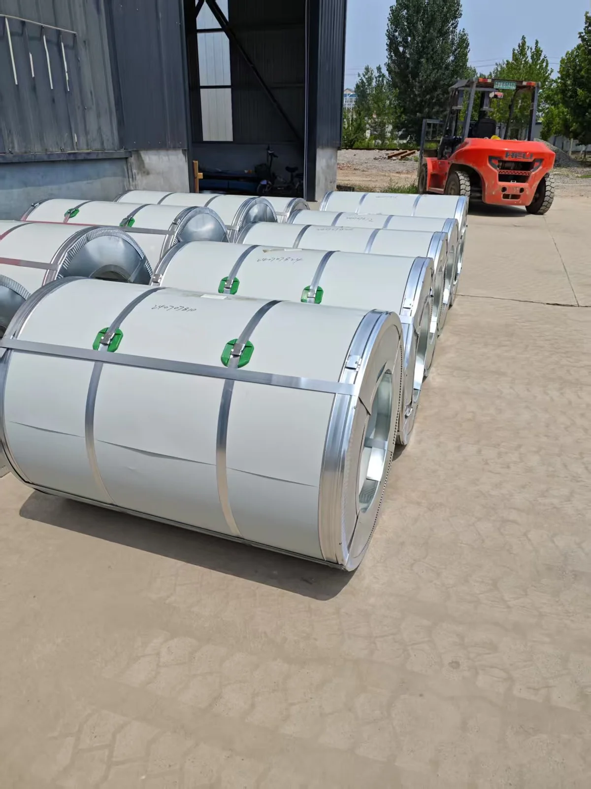 Galvanized steel coils staged at warehouse — quality-controlled supply from our partner mills